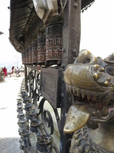 Prayer wheels (left) flanked by bronze lion-headed dragons (right) at Harati Devi Temple